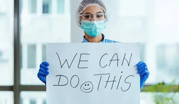 Nurse holding sign saying "we can do this"
