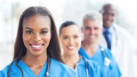 Nurses standing in front of a doctor