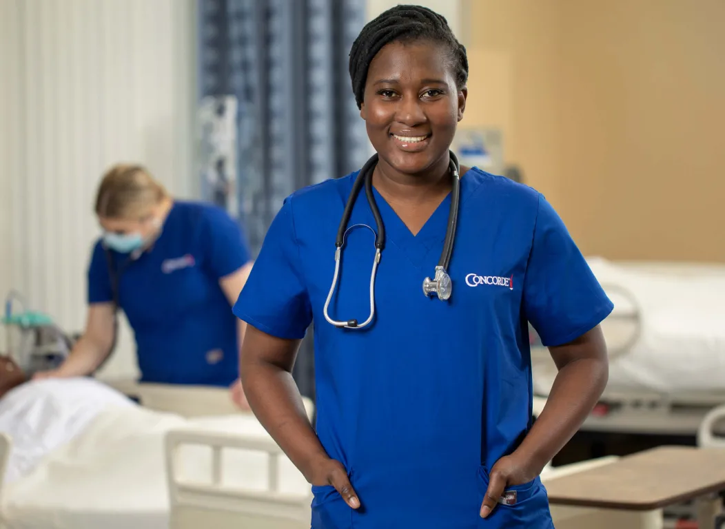 Prelicensure Nursing student standing in front of nurse and patient simulator..