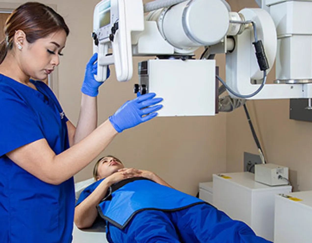 A radiology tech gives x-ray to patient's knee.