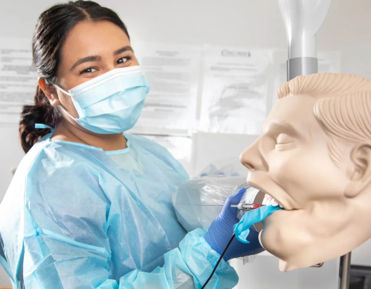 Dental Assistant cleaning the mouth of a dental manekin.