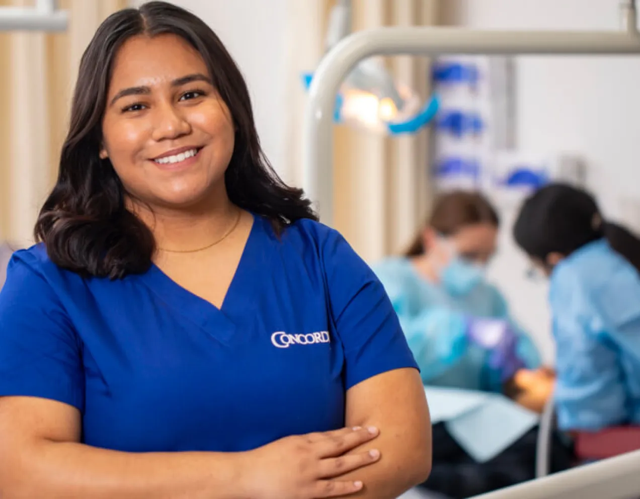 Dental Assistant in scrubs smiles with confidence