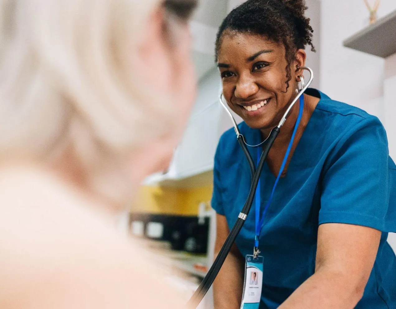 Nurse using a stethoscope during a patient assessment, showcasing clinical responsibilities in nursing.