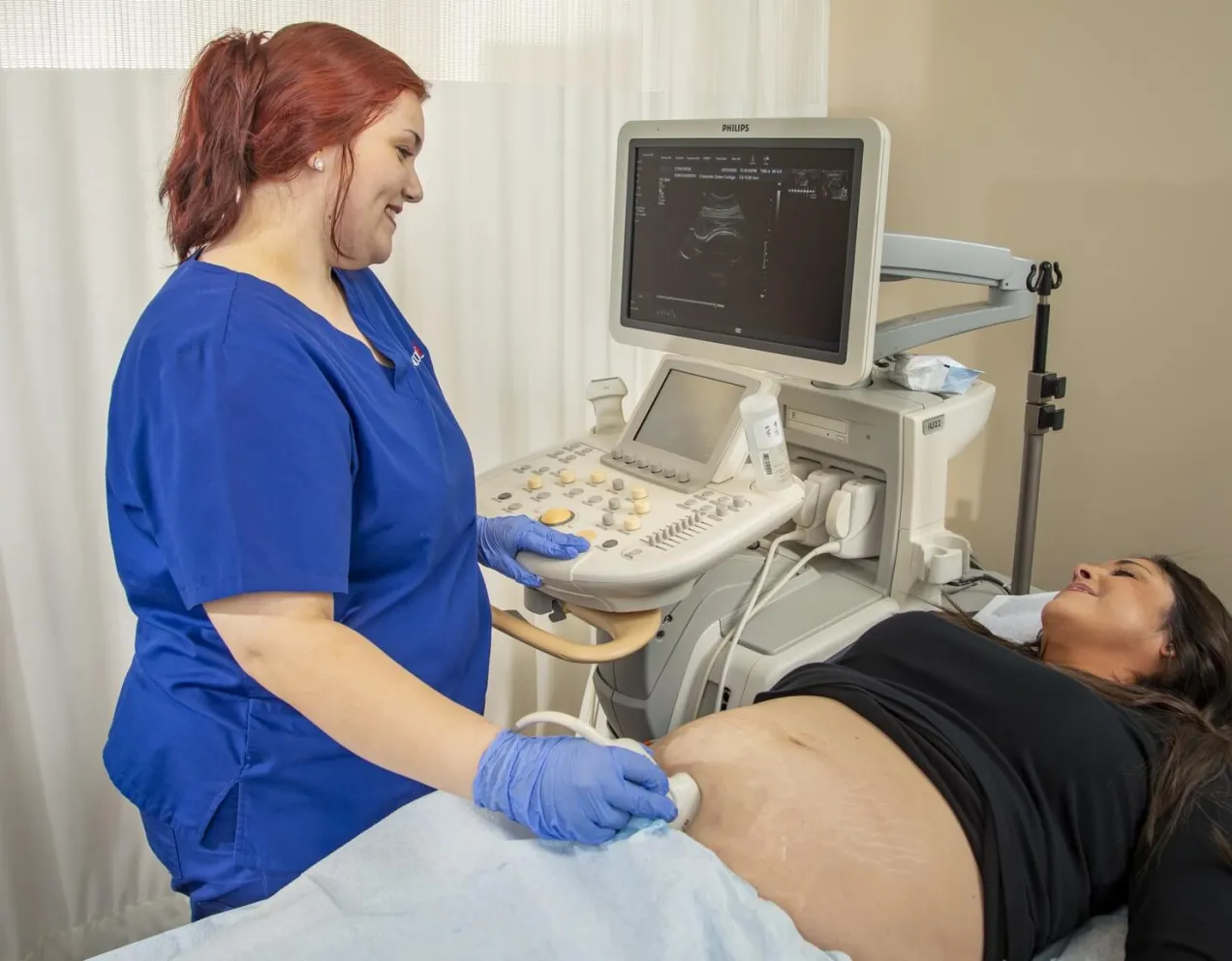Sonographer guiding patient through ultrasound exam during typical workday