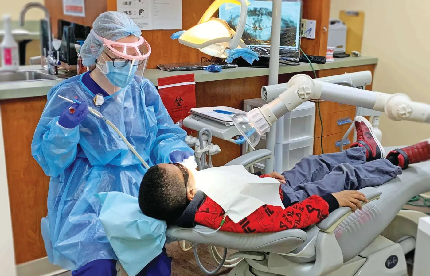 Concorde graduate performs pediatric dental cleaning during community event.