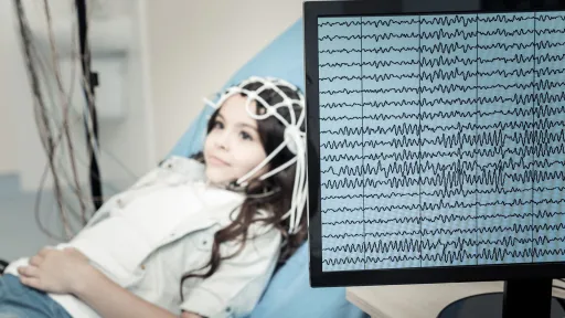 Brain wave patterns from EEG test being performed on a young female patient