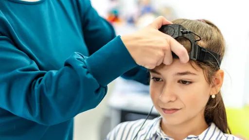 Neurofeedback EEG test being performed by therapist and young female child
