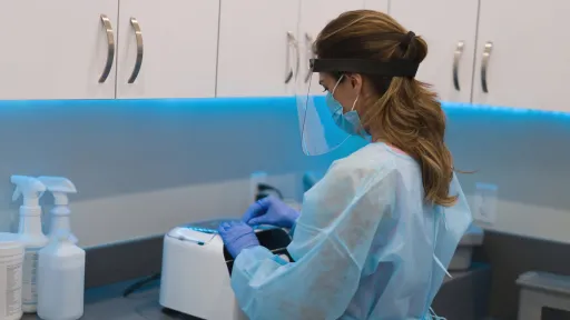 Sterile Processing Technician wearing PPE sterilizing medical equipment at the hospital.