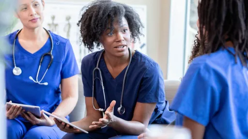 Diverse medical staff discuss nursing program.