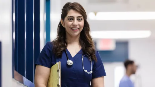 Registered nurse in scrubs holding a clipboard, representing professional duties of BSN-prepared nurses in healthcare.