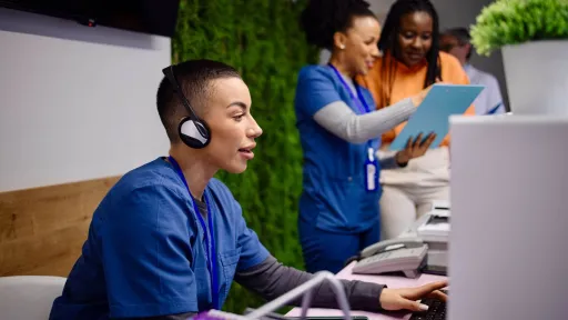 Medical assistant answering calls and assisting patients at a clinic, demonstrating front office healthcare duties.