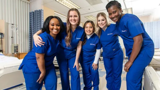 Concorde nursing students in scrubs pose together in a clinical lab, representing Oregon workforce training partnerships