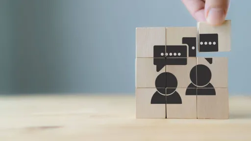 Wooden blocks showing two figures with speech bubbles, symbolizing the communication and interpersonal skills needed in a polysomnography career