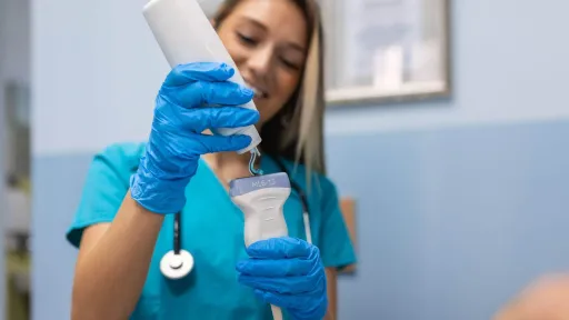 Sonographer applying gel to ultrasound transducer before performing a sonography exam