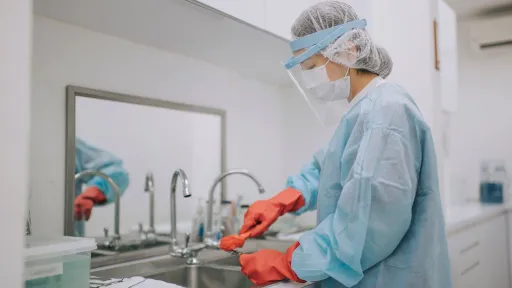 Sterile processing technician cleaning surgical tools at a sink, representing job responsibilities and outlook