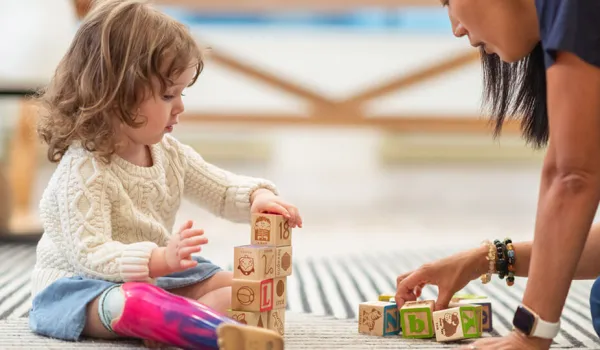 Occupational therapy assistant working with girl toddler