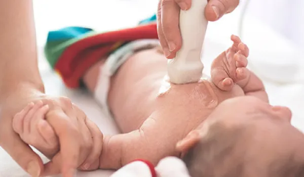 A sonographer performs a cardiovascular sonography on an infant as parent holds baby's hand. 