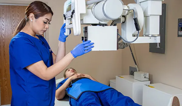 A radiology tech gives x-ray to patient's knee.