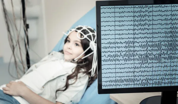 Brain wave patterns from EEG test being performed on a young female patient