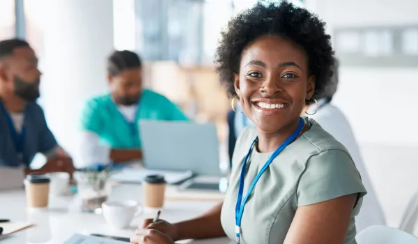 Smiling health care administrator meeting with professionals, representing careers in health care administration.