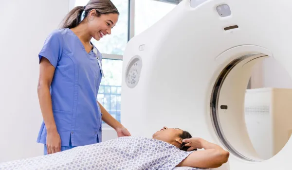 Radiologic technologist assisting a patient during a CT scan, representing careers in diagnostic imaging.