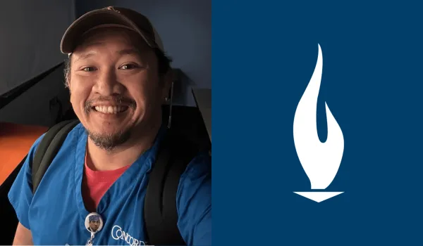 Arnold Septimo wearing blue Concorde scrubs and smiling for the camera