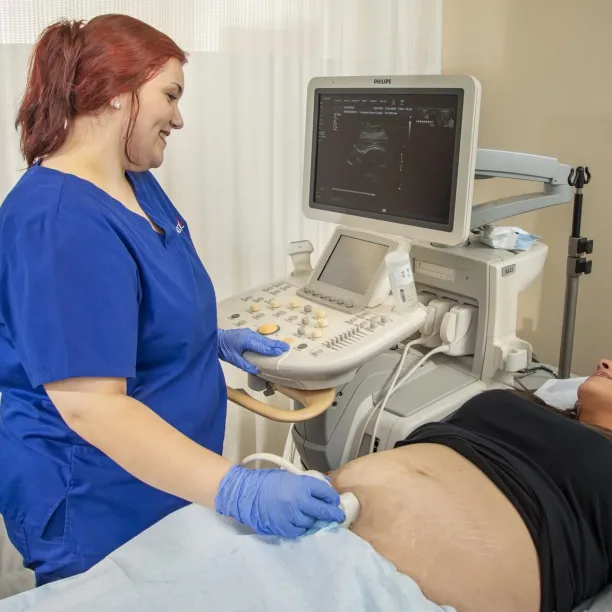 Sonographer guiding patient through ultrasound exam during typical workday