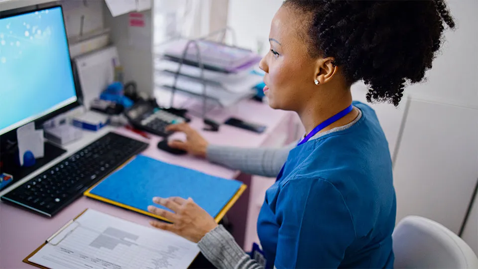 A medical assistant works to file medical records A medical assistant works to file medical records