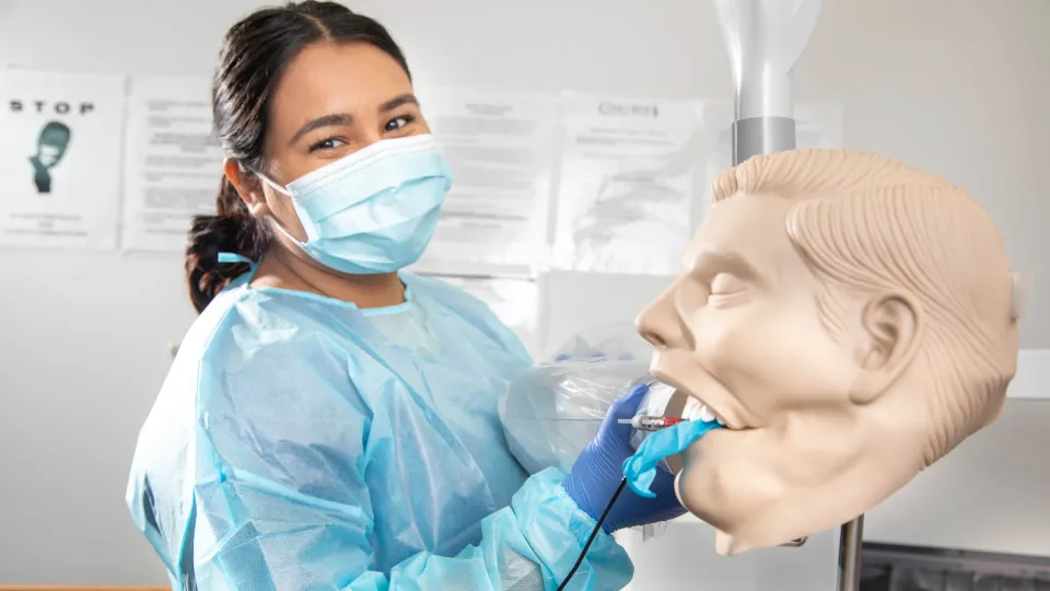 Dental Assistant cleaning the mouth of a dental manekin. Dental Assistant cleaning the mouth of a dental manekin.