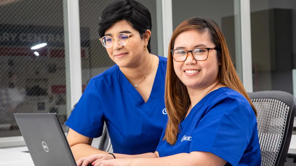 Medical office administrators reviewing files on laptop. Medical office administrators reviewing files on laptop.