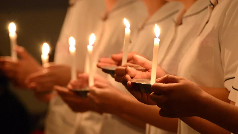 Nursing students hold candles during a capping and pinning ceremony that signifies the brotherhood and sisterhood of nurses. Nursing students hold candles during a capping and pinning ceremony that signifies the brotherhood and sisterhood of nurses.