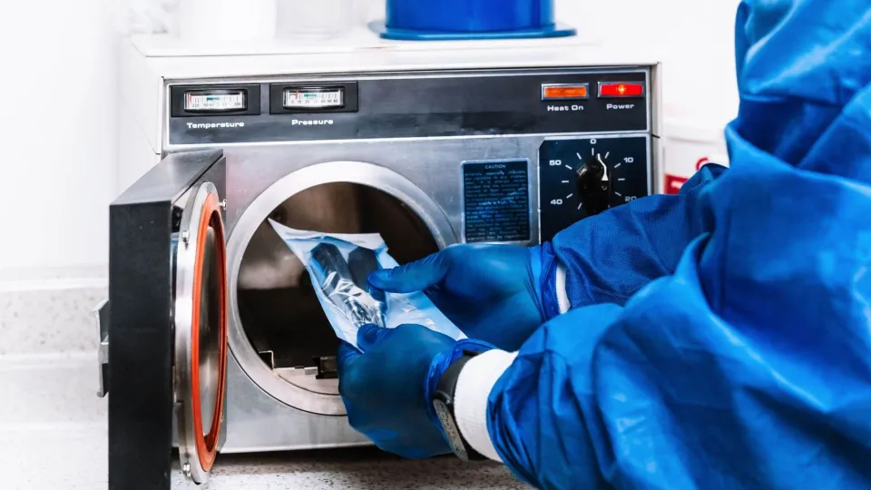 Sterile processing technician loading instruments into autoclave, demonstrating key skills learned in technician training. Sterile processing technician loading instruments into autoclave, demonstrating key skills learned in technician training.