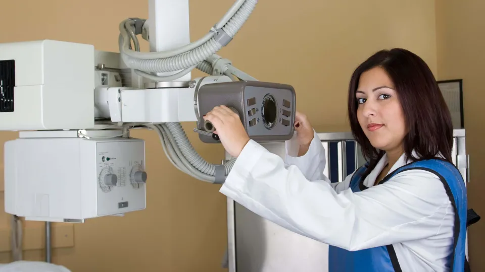 Radiologic technologist adjusting X-ray equipment before a diagnostic imaging procedure Radiologic technologist adjusting X-ray equipment before a diagnostic imaging procedure