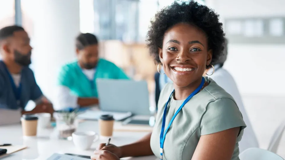 Smiling health care administrator meeting with professionals, representing careers in health care administration. Smiling health care administrator meeting with professionals, representing careers in health care administration.