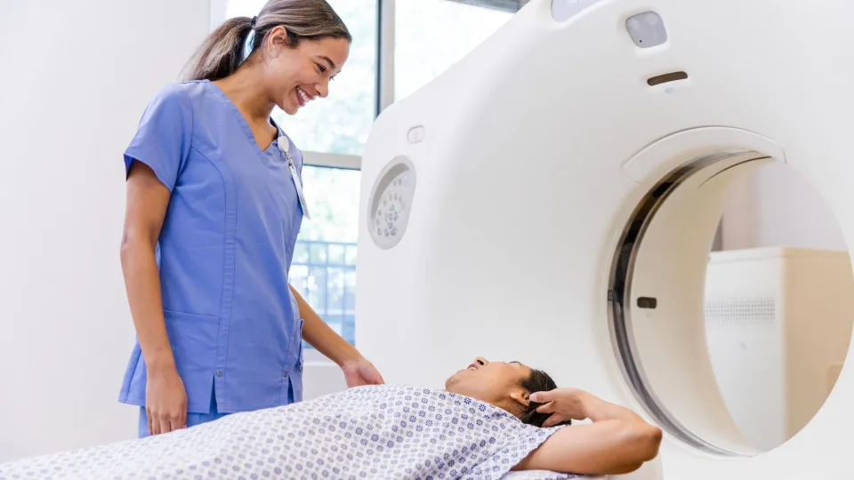 Radiologic technologist assisting a patient during a CT scan, representing careers in diagnostic imaging. Radiologic technologist assisting a patient during a CT scan, representing careers in diagnostic imaging.