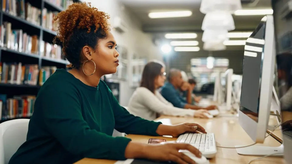 A focused woman with curly hair sits at a computer in a library or lab, working on the coursework that may be part of her healthcare administration degree prerequisites. A focused woman with curly hair sits at a computer in a library or lab, working on the coursework that may be part of her healthcare administration degree prerequisites.