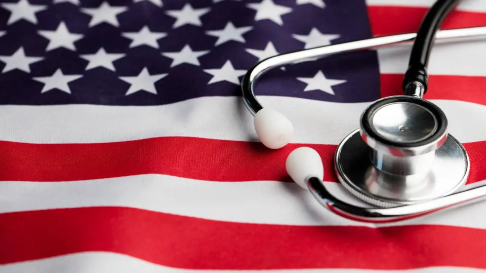 A medical stethoscope rests on top of a draped United States flag, symbolizing the career path transition from a military medic to a registered nurse.