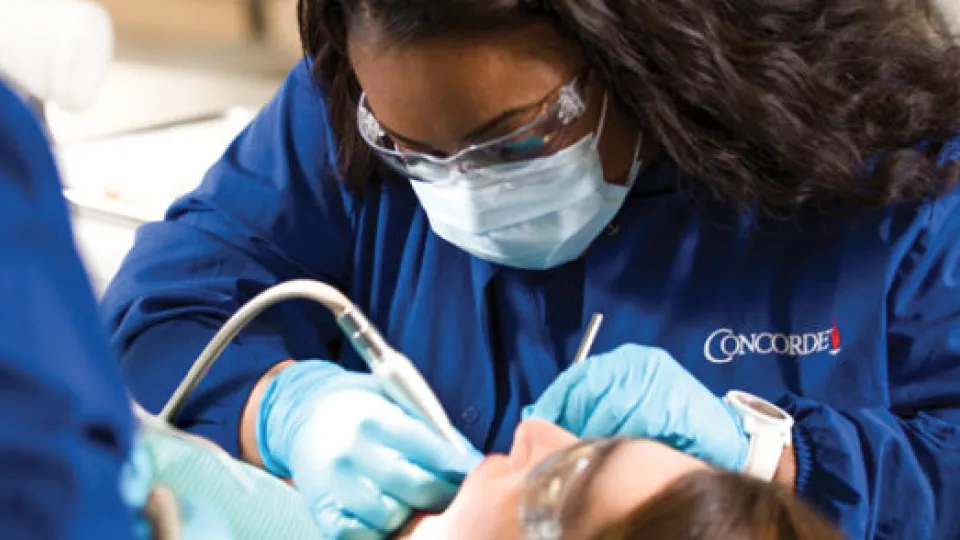 Concorde Career College Dental Assistant student suctioning mouth up close