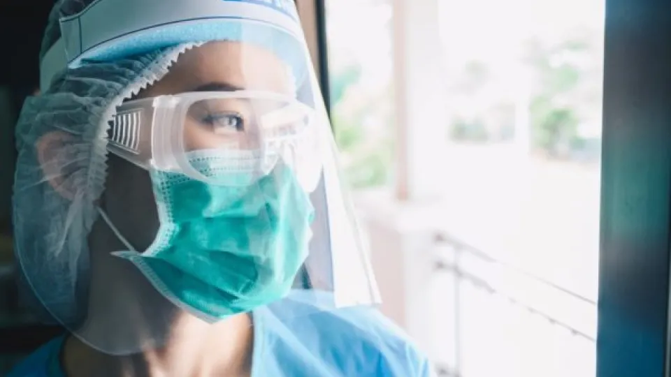 Masked Nurse looking out window Masked Nurse looking out window