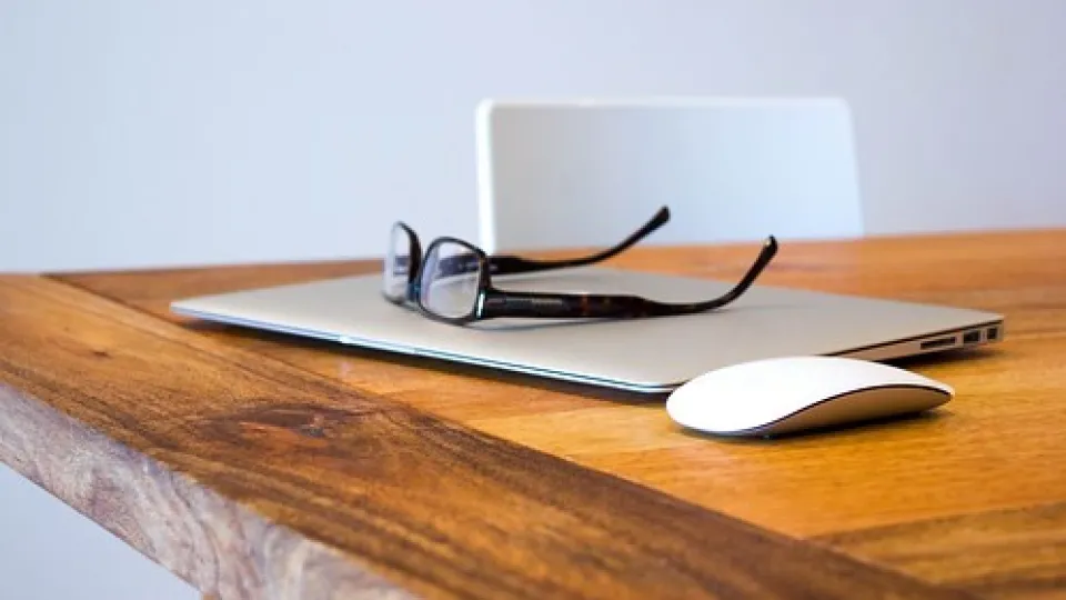 computer on table with glasses computer on table with glasses