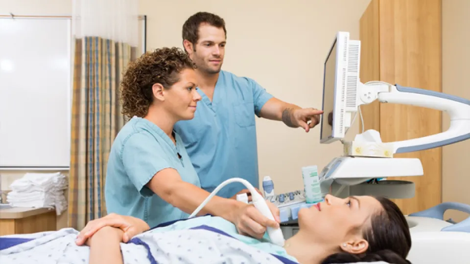 Diagnostic medical sonography being performed on patient's thyroid.