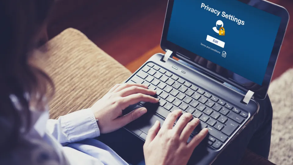 "Privacy settings" on the screen. Woman hands over the keyboard health care