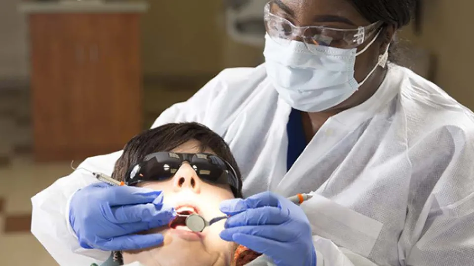 Dental hygienist providing dental care to patient