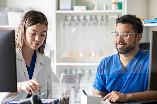 Pharmacy tech assisting pharmacist fill prescription