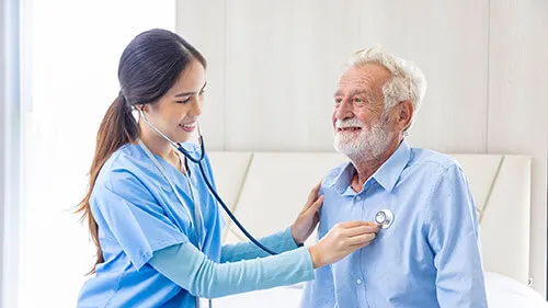 respiratory therapist examines older man with stethoscope