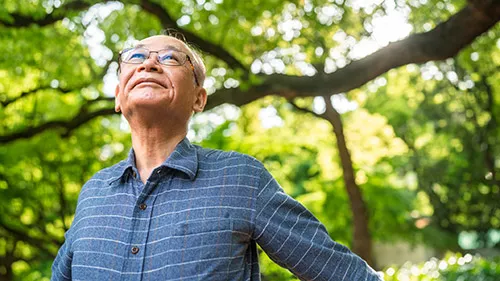 senior man taking a deep breath in nature