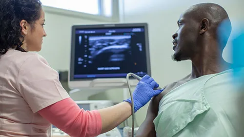A sonographer scans a patient's shoulder to look for underlying injuries
