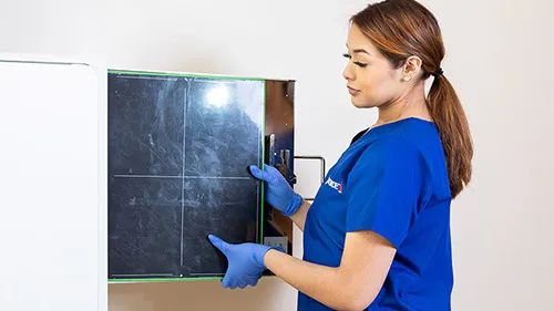 An X-Ray Tech maintaining imaging equipment.