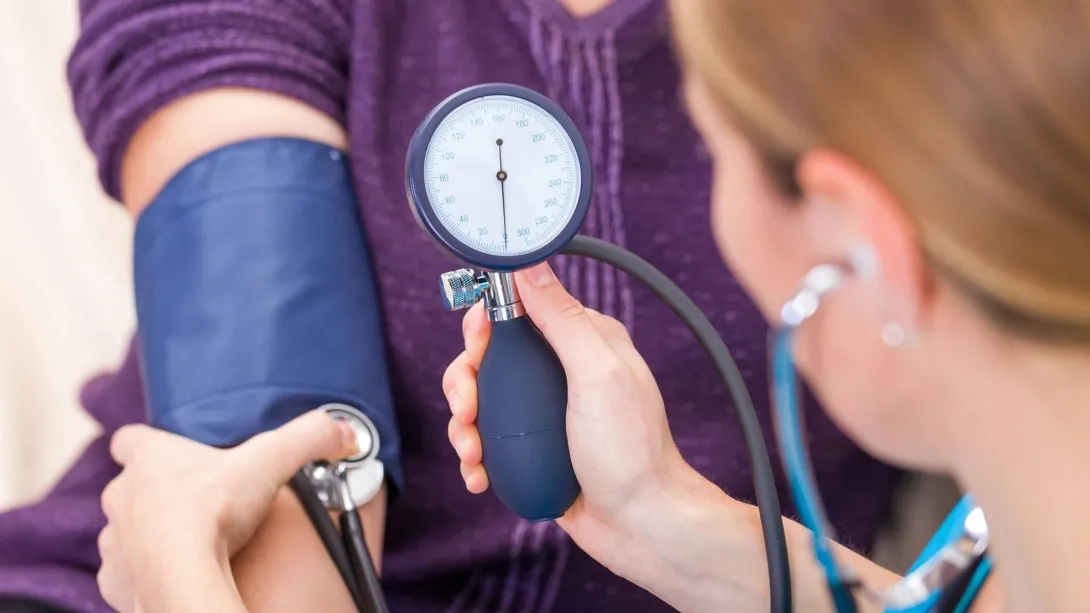 Medical Assistant duties performing blood pressure check.